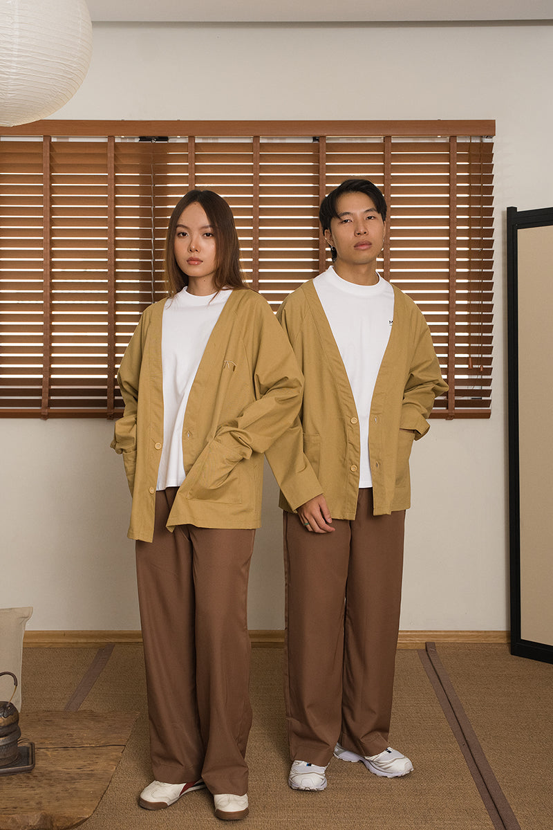 Two people wearing matching khaki kimono and brown pants from MINUS-E standing in Japanese inspired interior.